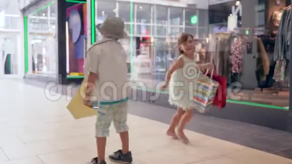 黑色星期五手里拿着购物袋的快乐孩子对购物中心的新购物感到高兴视频的预览图