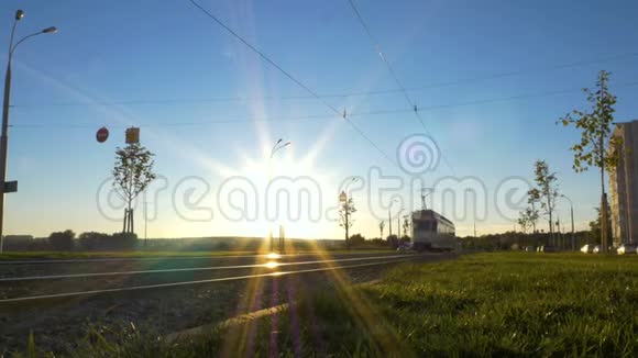 日落时明亮的太阳背景上两条电车向不同的方向分散城市电力运输视频的预览图