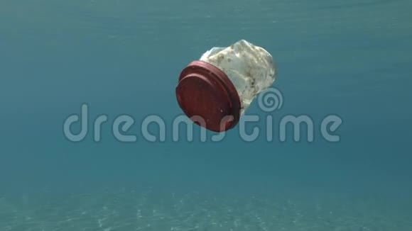 塑料污染一个带红色盖子的白色塑料杯漂浮在地中海蓝色的水面下视频的预览图