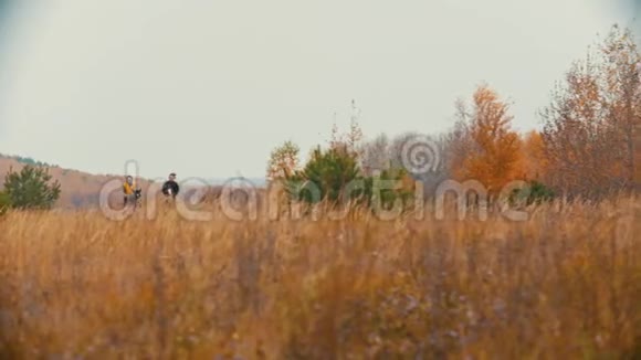 两个女人骑着马背在秋天的田野上奔跑视频的预览图