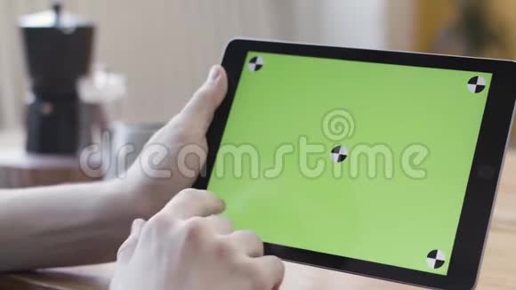 用绿色屏幕关闭手握数字平板电脑滚动滑动和敲击他的设备视频的预览图