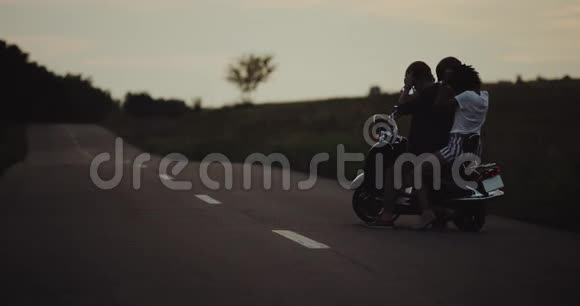 晚上一对夫妇准备骑他们的复古摩托车戴上头盔然后上路视频的预览图