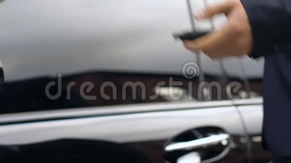 成功的商人用遥控钥匙打开车门关上视频的预览图