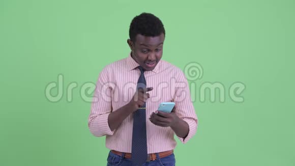 快乐的年轻非洲商人用电话得到好消息视频的预览图