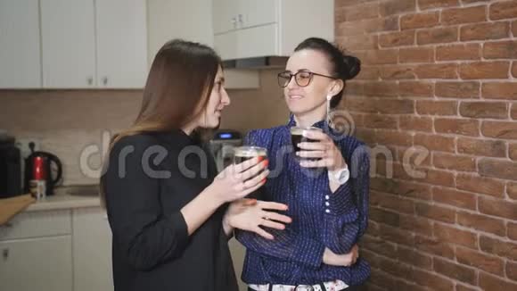 两个商务女性在厨房办公室喝咖啡休息时聊天视频的预览图