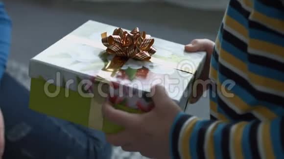 幼儿双手向母亲赠送节日礼品盒视频的预览图