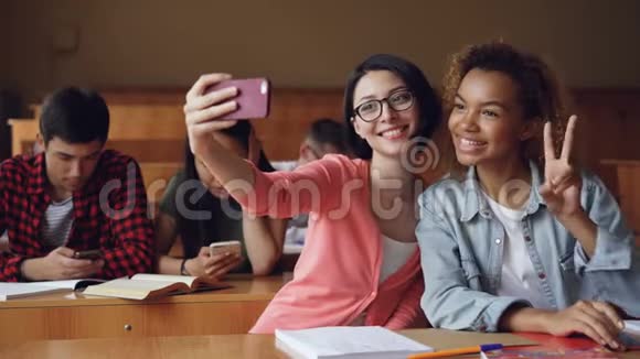 在大学里活泼开朗的女生们都在用智能手机拍自拍而女生们则在摆手视频的预览图