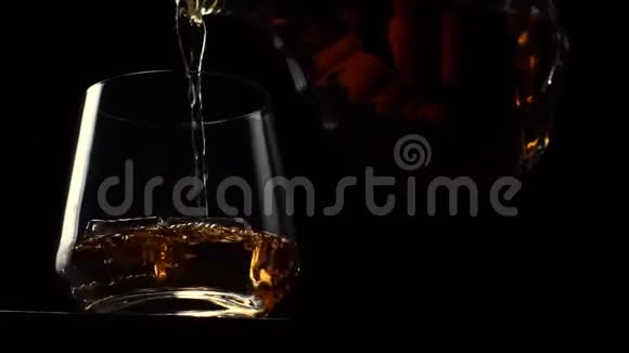 将酒精饮料威士忌或波旁威士忌倒入玻璃杯中视频的预览图