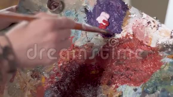 人在调色板上混合油漆视频的预览图