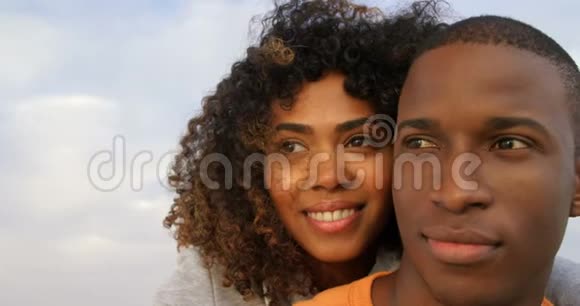 非裔美国人夫妇在海滩上互相拥抱的正面景色视频的预览图
