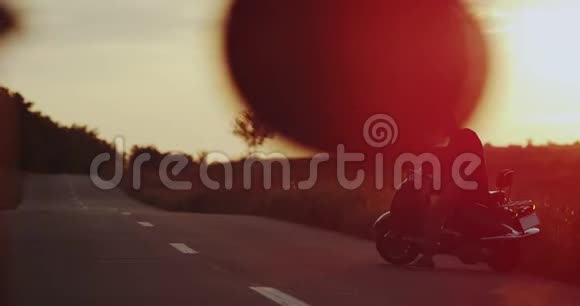 路中间天空灯火辉煌年轻人骑着复古的摩托车等着他的年轻视频的预览图