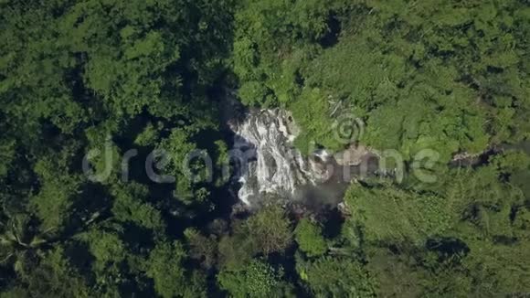 在亚洲的印度尼西亚巴厘岛用无人驾驶飞机在丛林中央美丽的瀑布上空飞行视频的预览图