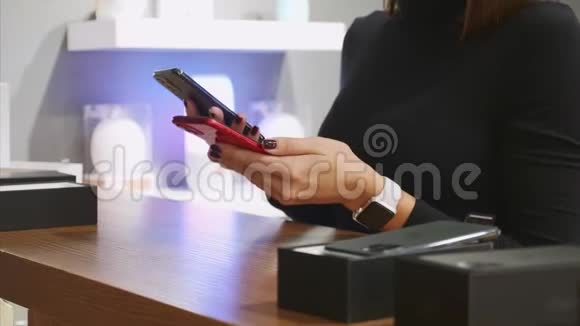 无法辨认的女人在电子商店里选择智能手机视频的预览图