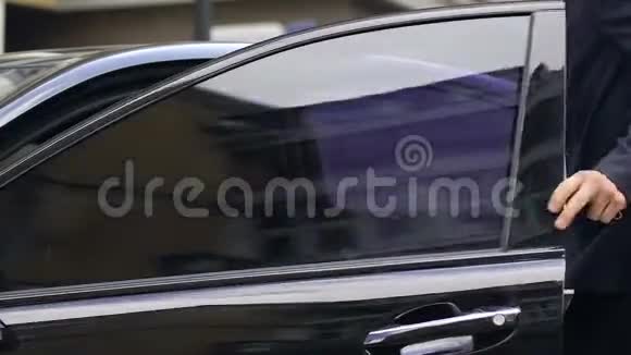 穿西装的帅哥坐在黑色时髦车的驾驶座上有钱人视频的预览图
