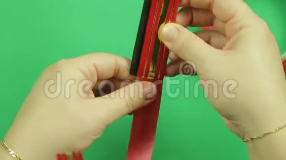 女人手包一条红色丝带用于在模板上做礼物蝴蝶结绿色背景视频的预览图