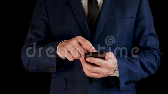 穿商务西装的商人在黑色背景下通过智能手机进行通信视频的预览图