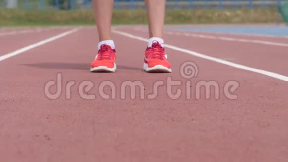 一名年轻女子运动员的腿上戴着红色的鼻标她在一天的训练中在城市体育场跑步视频的预览图