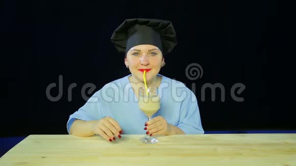 女人在黑色背景下烹饪品尝水果冰沙并显示标志OK视频的预览图