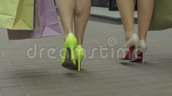 女人的腿在街上拿着购物袋走路视频的预览图