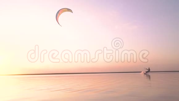 湖上黎明一个人驾驶一只训练风筝蹦蹦跳跳地飞向空中慢动作视频的预览图