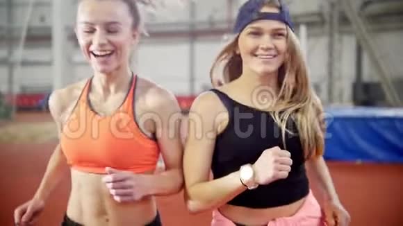 两个年轻的女运动员朋友在跑道上跑步视频的预览图