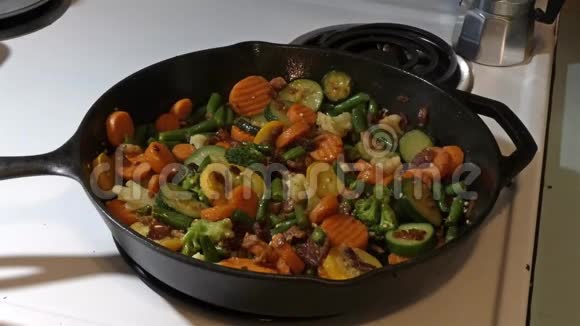 在满是蔬菜的锅里加入调味料视频的预览图