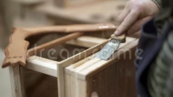 男性手刮木巢箱底部的硬胶视频的预览图
