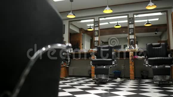 男子理发店室内有砖墙和带铬柄的皮椅视频的预览图