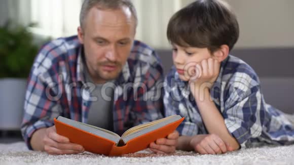 男生听爸爸读刺激的冒险书热爱文学视频的预览图