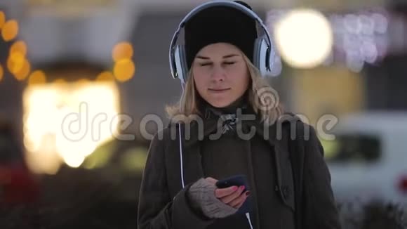 冬天女人在晚上城市的智能手机里思考和写信息视频的预览图