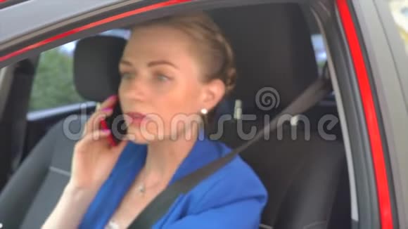 套房里的女人坐在车里在电话里说话突然她开始争论看着窗外女孩的波浪视频的预览图