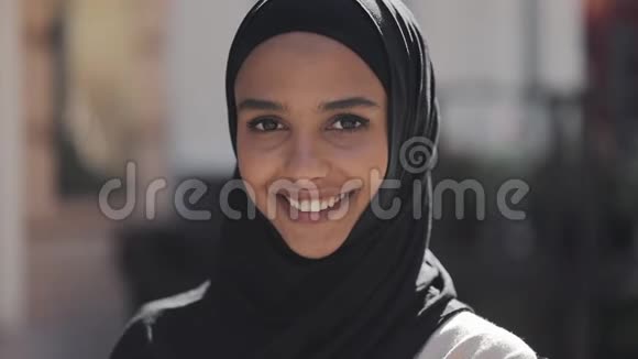 年轻美丽的穆斯林妇女戴着头巾的肖像在老城区笑得欢快快关门视频的预览图