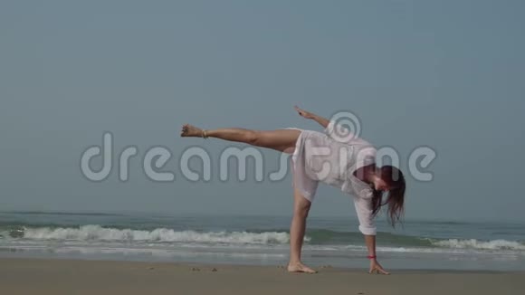 年轻女子在海边练习瑜伽健身运动瑜伽和健康的生活方式4K视频的预览图