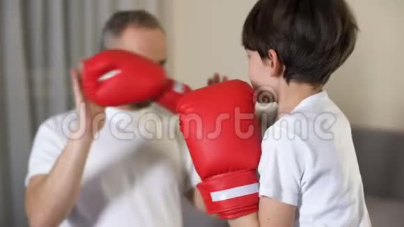小男孩和他的继父拳击学习进攻家庭聚会视频的预览图