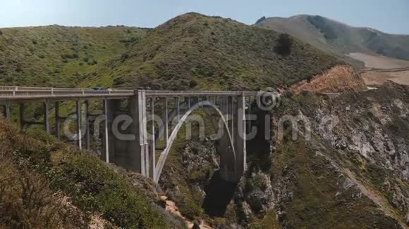 在著名的加州大南部通过标志性的比克斯比溪桥穿过1号高速公路的车景广阔的背景镜头视频的预览图