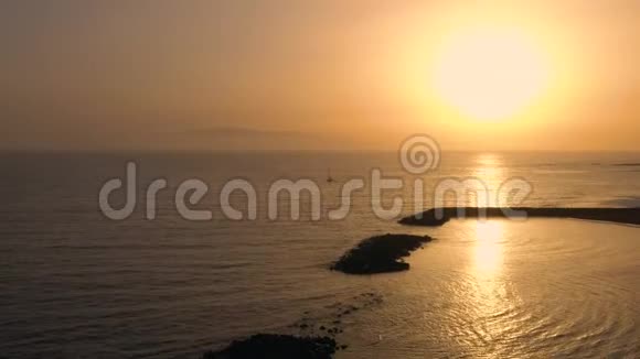 在美丽的日落背景下鸟瞰大西洋表面游艇返回码头视频的预览图
