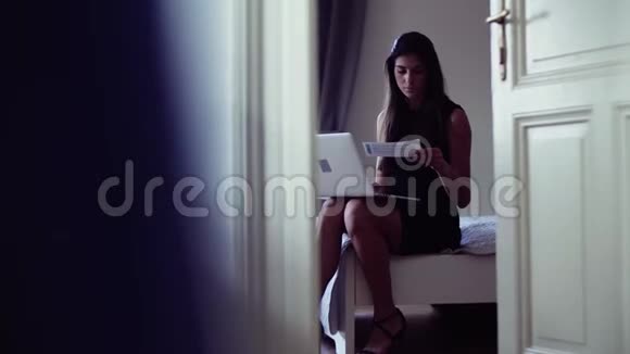 年轻的女商人出差坐在酒店房间里用笔记本电脑视频的预览图