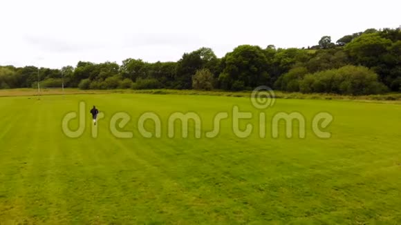 微风习习男子在绿野慢跑视频的预览图