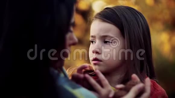 一位年轻的母亲在日落时带着一个小女儿在秋天的大自然里说话视频的预览图