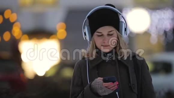 冬天女人在晚上城市的智能手机里思考和写信息视频的预览图