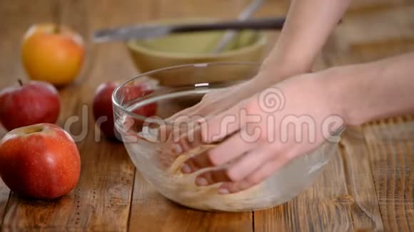 女人的手在厨房捏面团做自制苹果蛋糕视频的预览图
