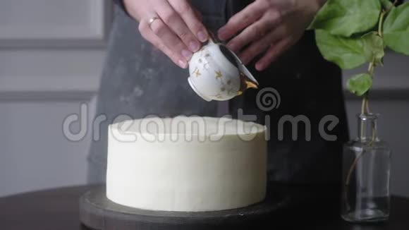糕点女孩把巧克力倒在白色奶油蛋糕上慢动作视频的预览图