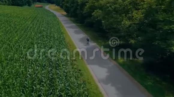 骑自行车的人骑自行车在森林田野路上视频的预览图