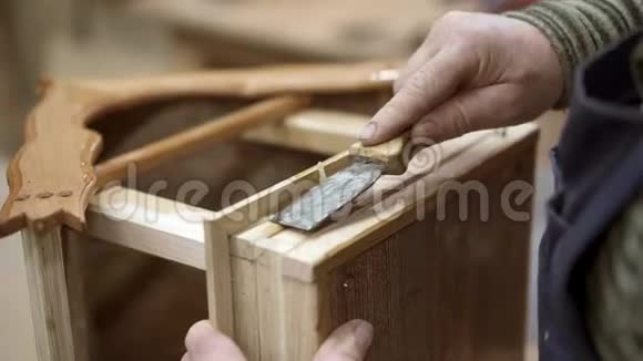 男性手刮木巢箱底部的硬胶视频的预览图