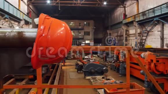 建筑工厂在后台工作的人前景上的橙色头盔视频的预览图