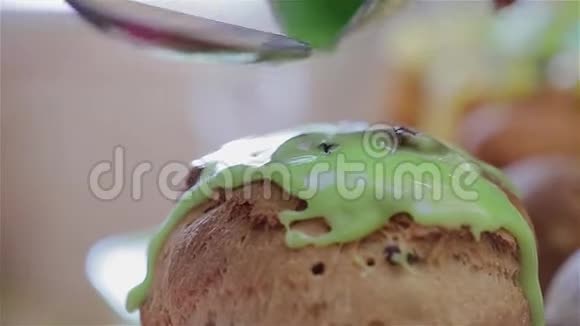 厨师手中的勺子特写厨师在复活节蛋糕上涂上糖霜釉是绿色的视频的预览图
