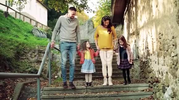 秋天一个有孩子的小家庭在城里的户外楼梯上视频的预览图