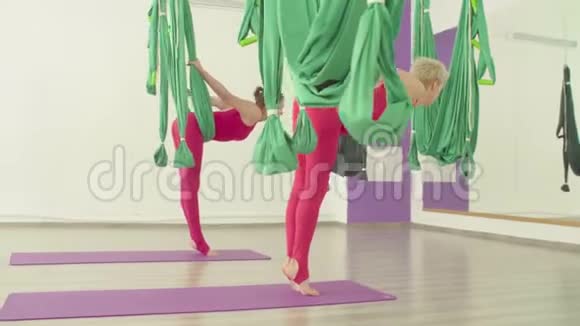 空中瑜伽两个女人坐在吊床上视频的预览图