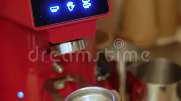 一台电动咖啡机将刚烤好的咖啡豆磨成滤筒视频的预览图