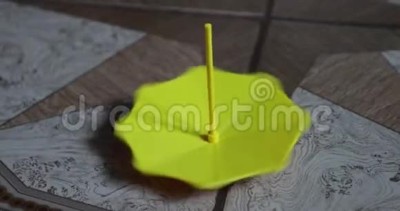 黄色的小塑料伞绕着它的轴旋转视频的预览图